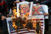 Палестинцы сжигают плакаты с изображением Нетаньяху и Трампа во время протеста против намерения США переместить свое посольство в Иерусалим и признать город Иерусалим столицей Израиля в Рафахе в южной части сектора Газа.