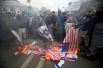 Протестующие сжигают американские и израильские флаги во время акции в ответ на признание Дональдом Трампом Иерусалима столицей Израиля, Лахор, Пакистан.