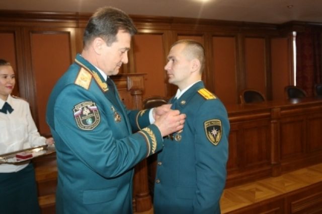 Александр Тиртока вручает награду сотруднику ведомства