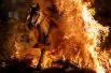 Мужчина на лошади прыгает через костер во время огненного фестиваля Luminarias в канун дня Святого Антония в деревне Сан-Бартоломе-де-Пинарес к северо-западу от Мадрида, Испания. 16 января 2018 года. 16 января 2018 года. 