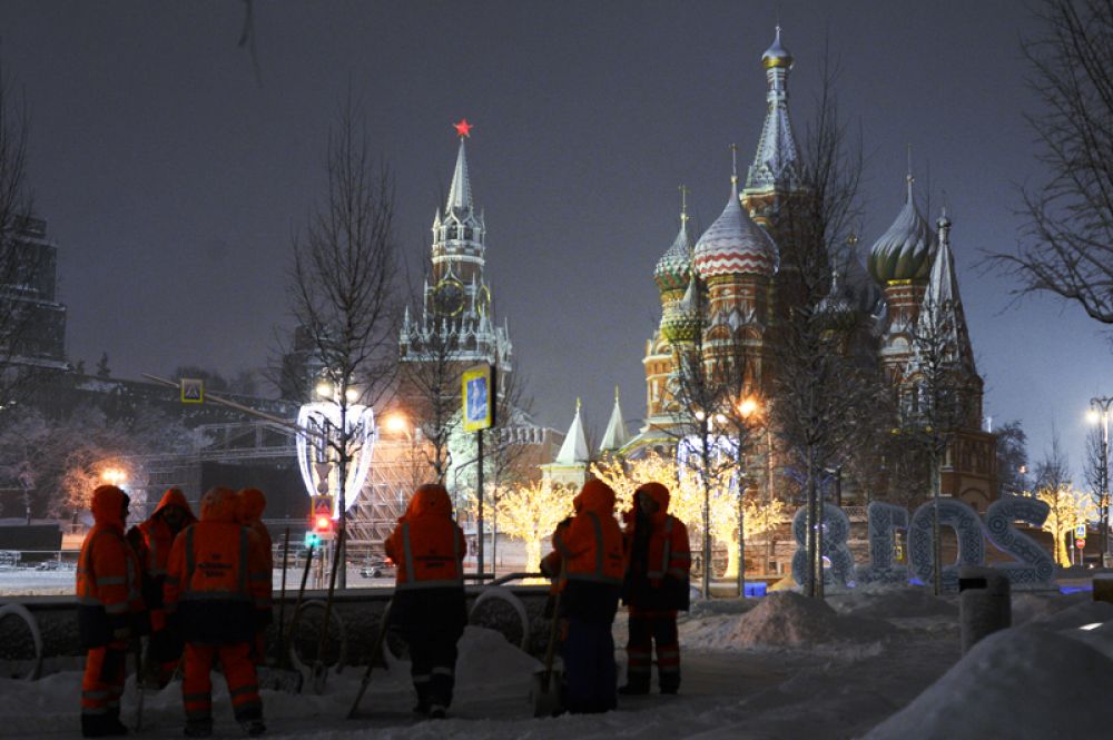 Сотрудники коммунальных служб убирают снег на улице в Москве.