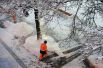 Сотрудники коммунальных служб убирают снег на улице в Москве.
