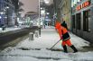 Сотрудник коммунальной службы убирает снег на улице в Москве.