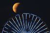Лунное затмение над колесом обозрения на пирсе Санта-Моники, Калифорния, США.