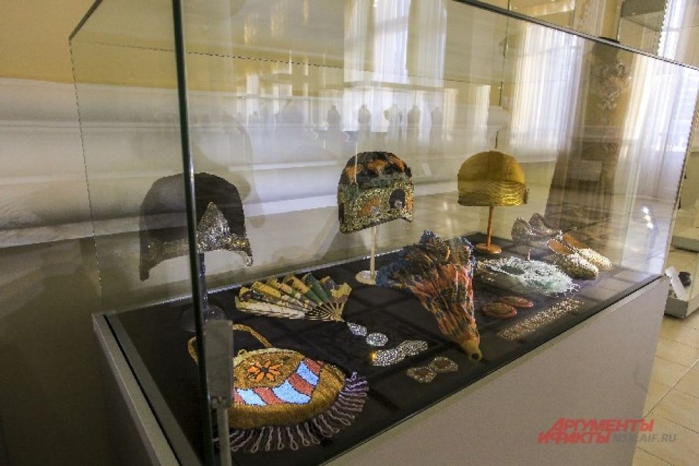 В экспозиции представлены также вышитые бисером сумочки и кокетливые веера.
