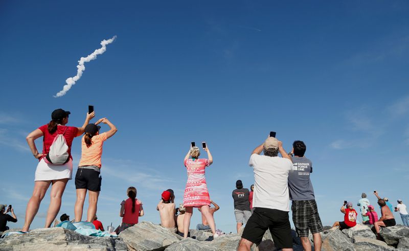 Зрители наблюдают за запуском ракеты из космического центра имени Кеннеди во Флориде..