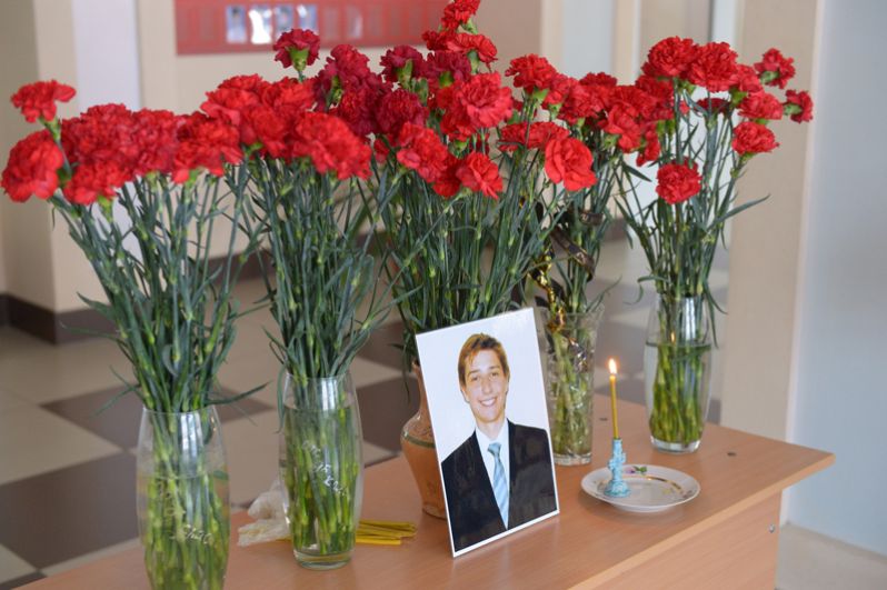 Цветы и свечи в холле 8-й школы Орска у фотографии ученика Ильи Полетаева, погибшего в крушении самолета Ан-148 .