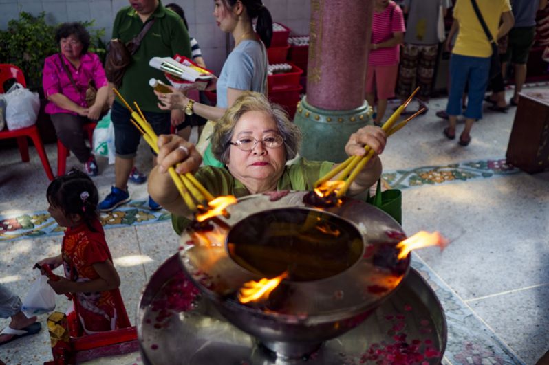 Женщина совершает обряд в одном из храмов в китайском квартале Бангкока, Таиланд. 