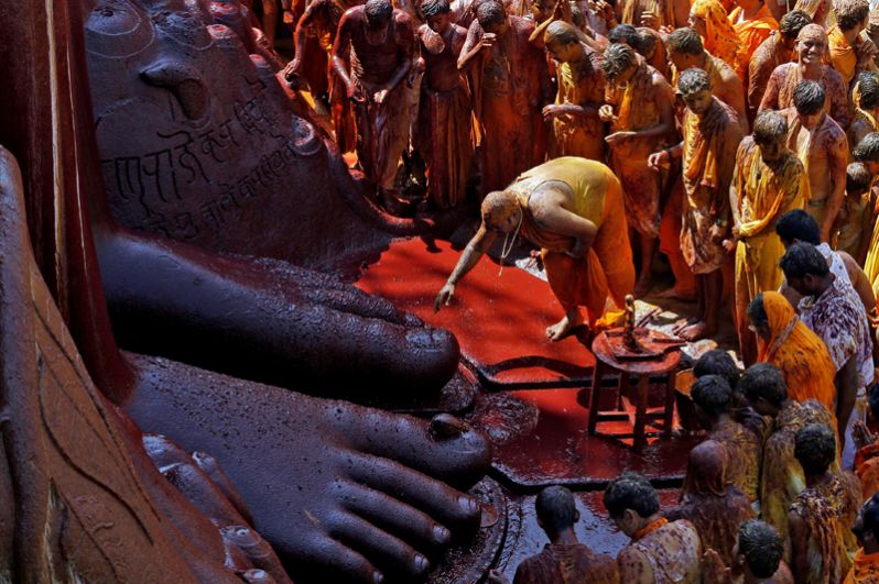 Верующий прикасается к ногам статуи бога Гомматешвары во время церемонии помазания, Шраванабелагола, Индия. Согласно джайнийскому учению, такой ритуал способствует очищению души и избавлению ее от цепи перерождений.