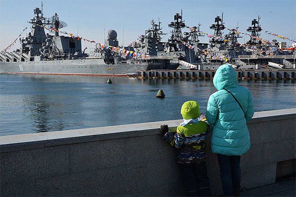 Гвардейский ракетный крейсер «Варяг» (слева) во время празднования Дня защитника Отечества во Владивостоке.