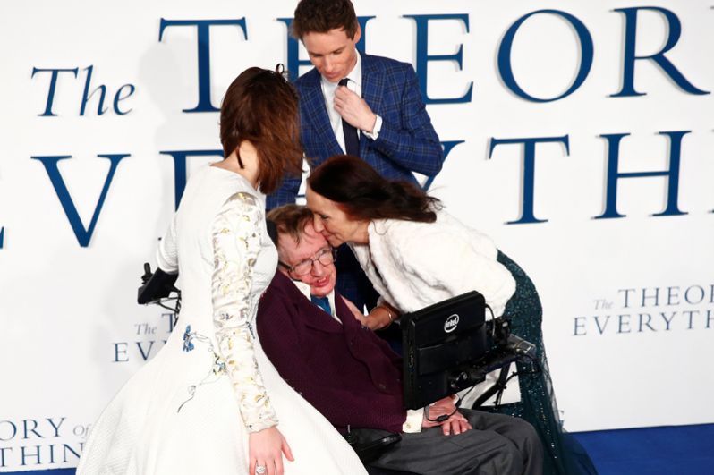 Бывшая жена Стивена Хокинга Джейн Уайлд целует его на премьере фильма «Вселенная Стивена Хокинга» в Лондоне. 9 декабря 2014 года. Рядом — исполнители главных ролей актеры Эдди Редмайн и Фелисити Джонс.