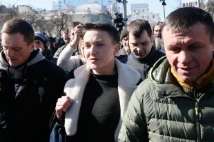 Надя Савченко сопровождается сотрудниками Службы безопасности Украины после задержания по обвинению в планировании военного переворота в Киеве.