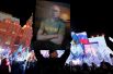 Мужчина держит плакат с изображением Владимира Путина во время концерта, посвященного четвертой годовщине присоединения Крыма к России на Манежной площади, Москва, Россия.