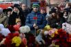 Жители несут цветы и мягкие игрушки к зданию торгового центра «Зимняя вишня» в Кемерово, где произошел пожар.