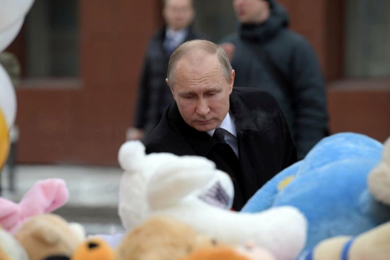 Владимир Путин у стихийного мемориала у фасада сгоревшего ТЦ, куда люди приносят цветы, свечи, игрушки и фотографии погибших.