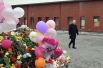 Владимир Путин у стихийного мемориала у фасада сгоревшего ТЦ, куда люди приносят цветы, свечи, игрушки и фотографии погибших.