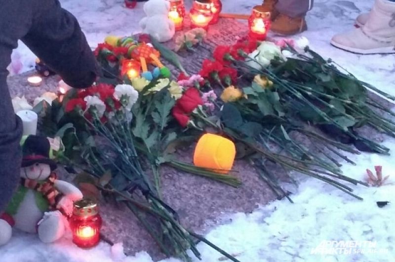 Люди зажигали свечи и возлагали цветы в память о жертвах трагедии в Кемерово.