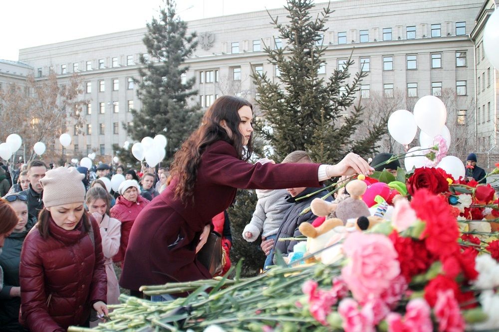 В Иркутске люди несут цветы и свечи.