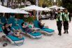 Полицейские проходят мимо отдыхающих в последний день перед закрытием острова Боракай.