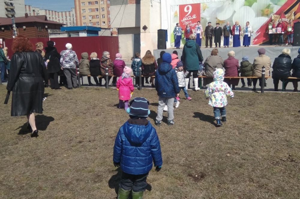 Дети водят хоровод возле сцены.