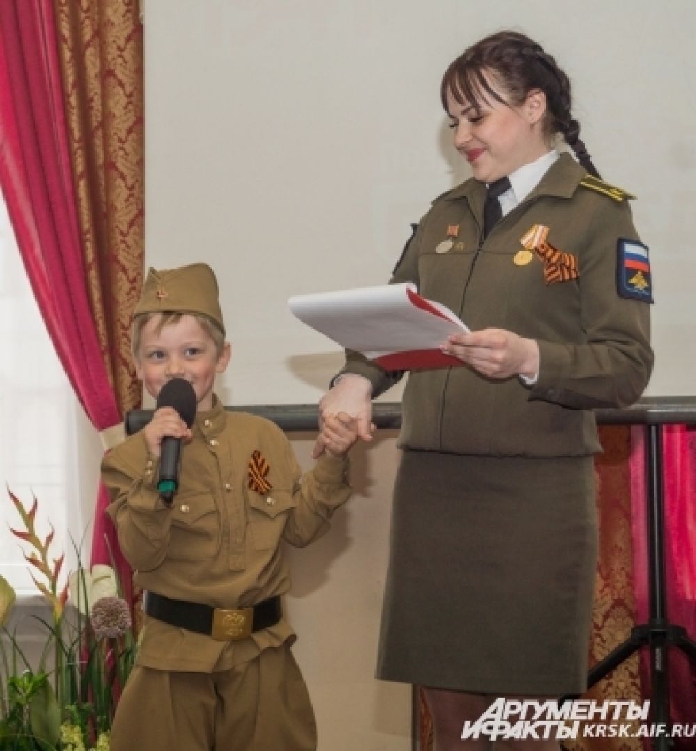 Самый маленький участник автопробега - четырехлетний Матвей Божков - читает стихи про своего прадедушку. Рядом с ведущей Катериной Чеканинской, курсантом Военно-инженерного института СФУ ничего не страшно.