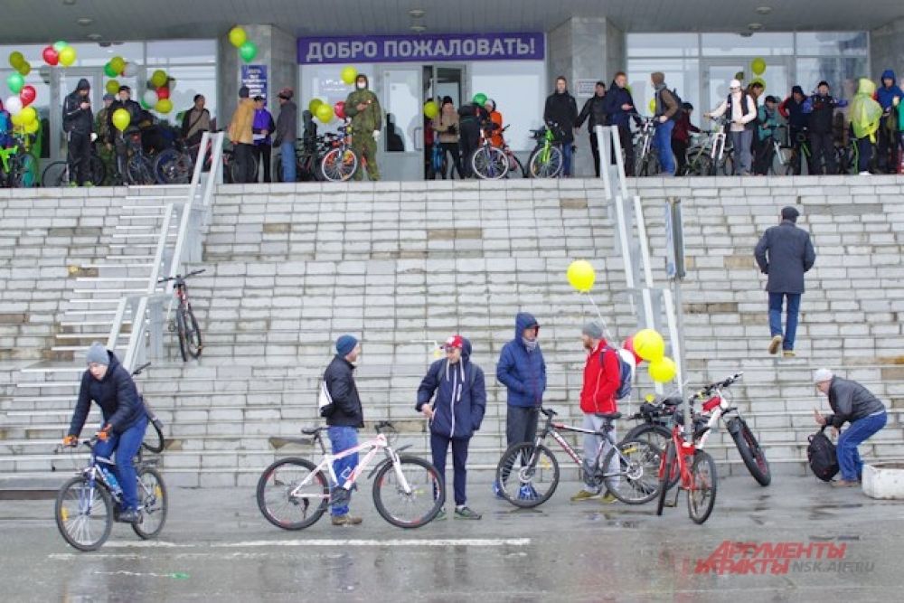 Но участники стали собираться в назначенном месте задолго до старта. Погода была совсем нелетней, от дождя и ветра велосипедисты укрывались под «крылом» библиотеки.