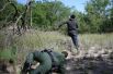 Мужчина, незаконно пересекший границу Мексики и США, убегает от американского патруля, Техас, США.