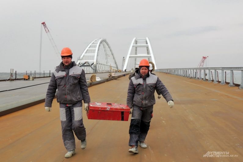 Строители с ящиком инструментов на фоне арок моста. 23 марта 2018 года.