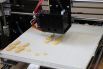 3D-принтер печатает брелоки в форме скрипичного ключа и значка биткоина