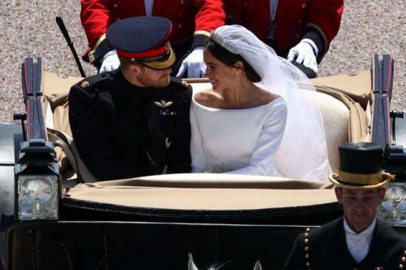 Меган Маркл и принц Гарри в открытой карете движутся по улицам Виндзора.