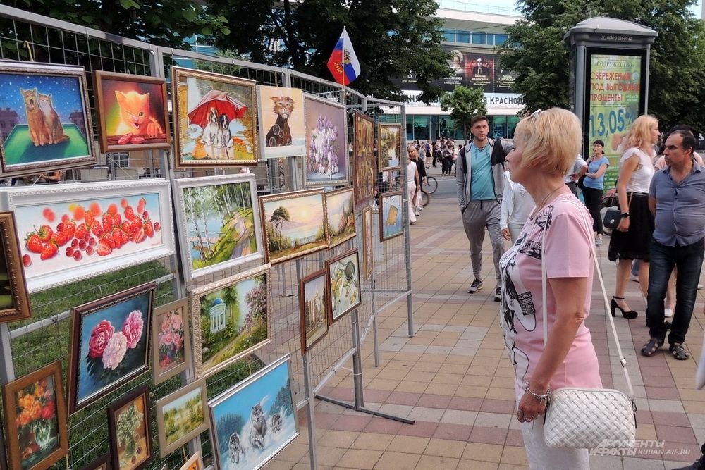 Женщина любуется картинами.