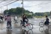Велосипедисты на затопленной после землетрясения дороге в Осаке.