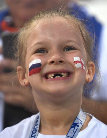 Юная болельщица с российским триколором и английским флагом на щеках.