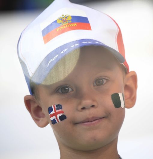 Юный фанат с флагами Исландии и Нигерии на лице.