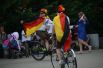 Болельщики сборной Германии, завернувшись в флаги, катаются на велосипедах.