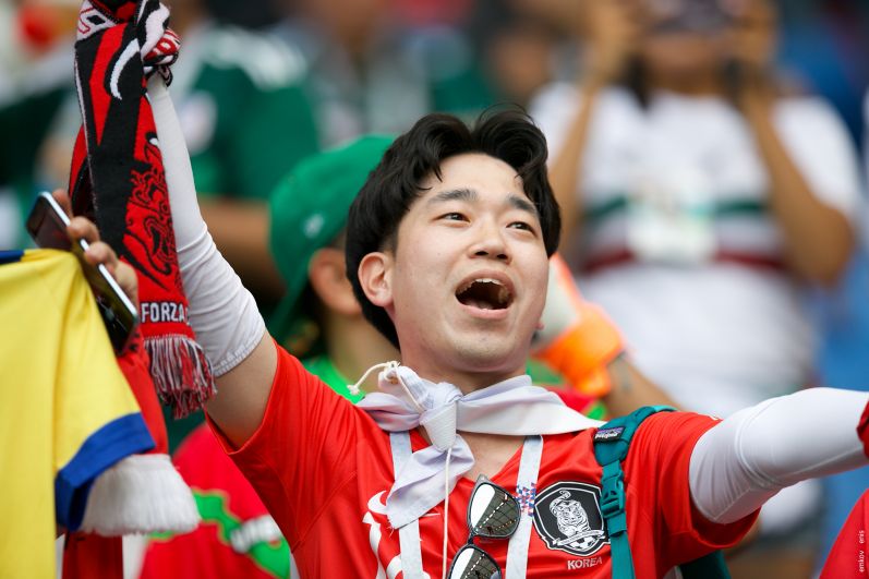 Корейский фанат радуется голу, который его команда забила в последние минуты матча. 