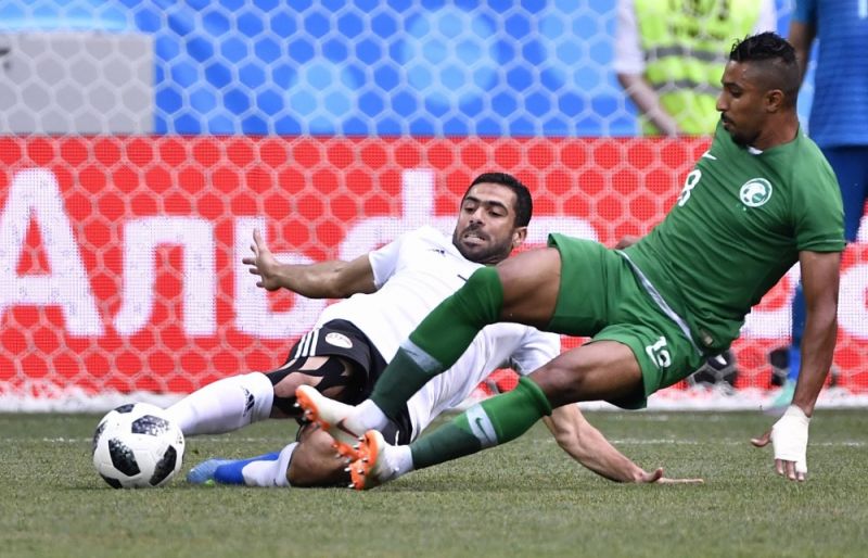 Ахмед Фатхи из египетской сборной не дает противнику Салему Аль-Досари завладеть мячом. 