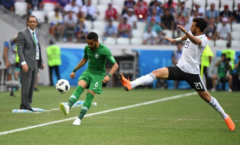Игрок египетской сборной Махмуд Хасан и Мохаммед Аль-Брейк из сборной Саудовской Аравии борются за мяч в первые минуты матча. 