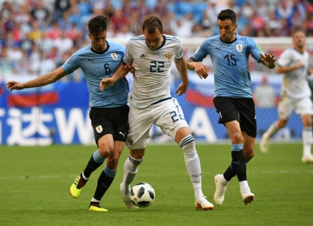 Уругвайцы сразу пытались прессинговать российских игроков. На фото - Артем Дзюба между двумя соперниками.