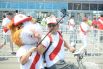 Аниматор фотографируется с фанатом сборной Перу на велосипеде при помощи селфи-палки.