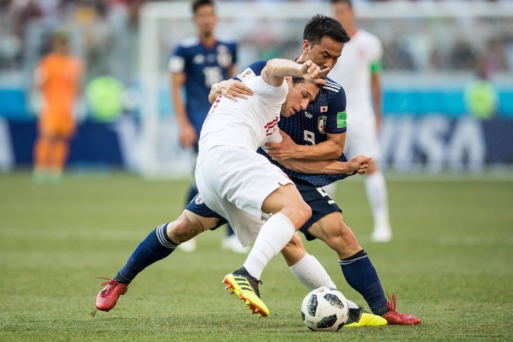 Полузащитник Гжегош Крыховяк и нападающий Синдзи Окадзаки борются за владение мячом. 