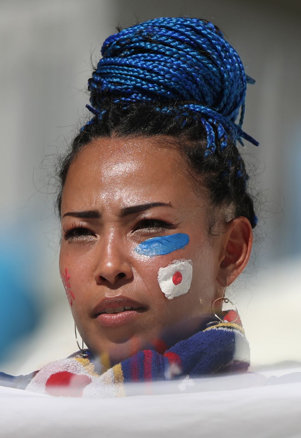 Японка с цветными африканскими косичками, убранными в пучок и флагом своей страны на щеке.