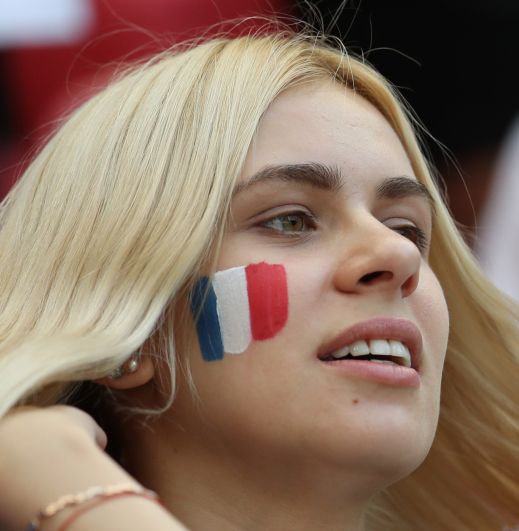 Фанатка сборной Франции с триколором на щеке.