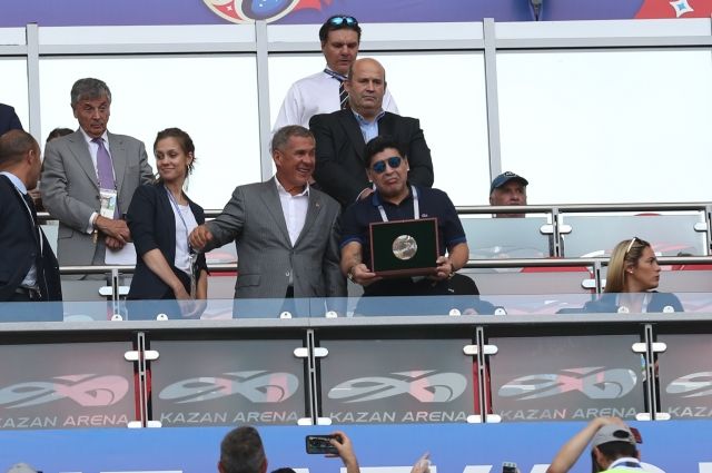 Марадона держит в руках сувенир.