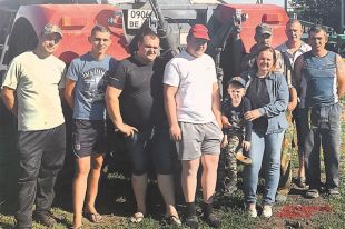 Татьяна с внуком, сыновьями (слева от неё) и механизаторами своего хозяйства.