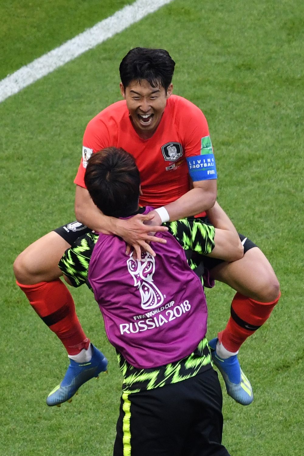 Нападающий сборной Южной Кореи Сон Хын Мин празднует свой гол сборной Германии, забравшись на руки к товарищу.