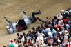 Карабинер падает с лошади во время традиционных скачек «Сиенское Палио», Италия.
