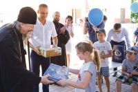 Митрополит Иоанн и Сергей Фуглаев вручают подарки детям из лагеря «Парус мечты».