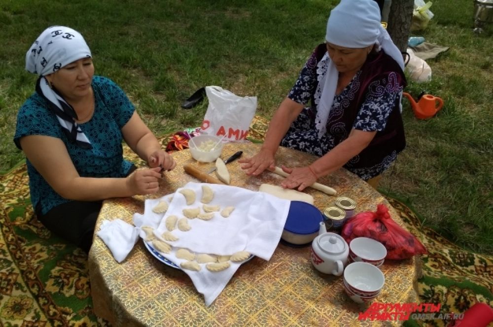 Женщины лепят национальные пироги в картошкой.