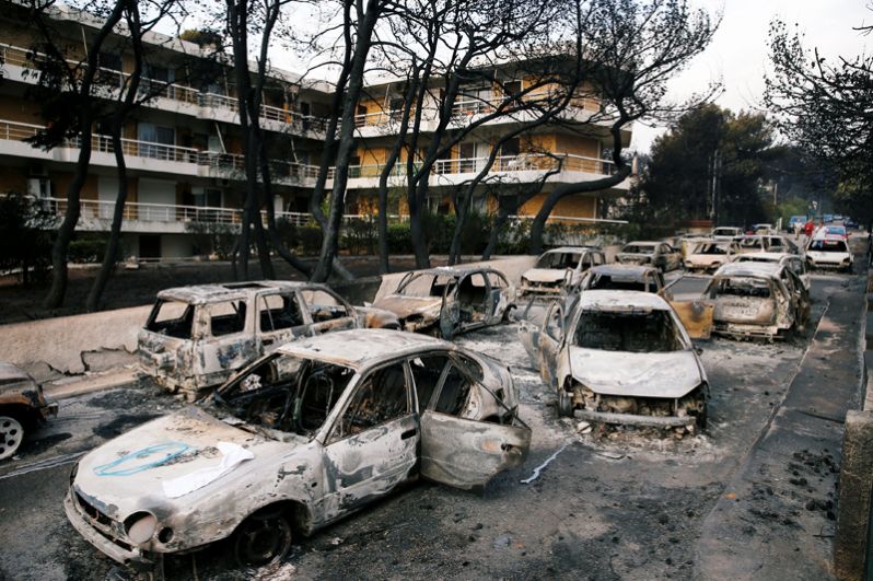 Сгоревшие автомобили после лесного пожара в Мати недалеко от Афин.